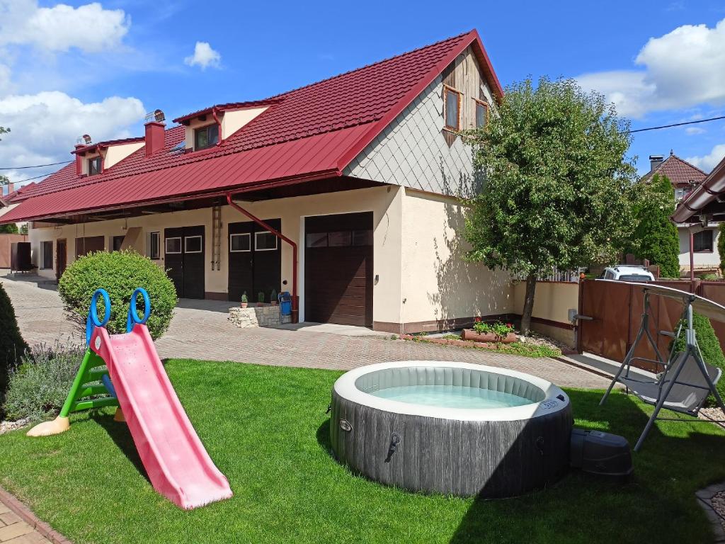 un patio trasero con un tobogán y una cama elástica y una casa en Chalupa u Mikeše, en Žďár nad Sázavou
