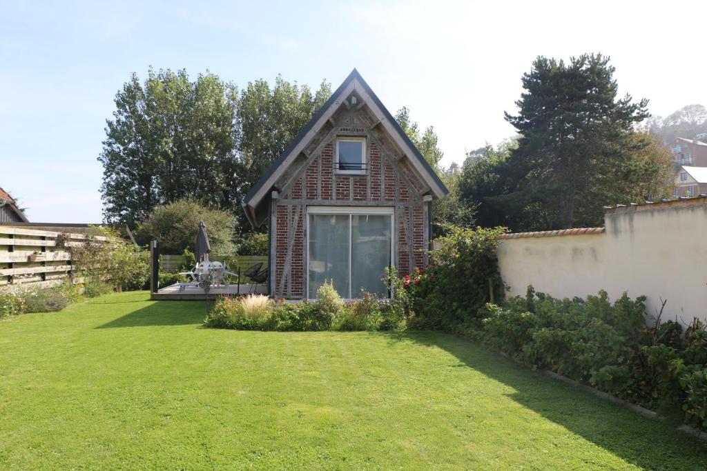 Hautot-sur-Mer的住宿－Jolie Maison en Bord de Mer à Pourville，一座带庭院的小砖屋