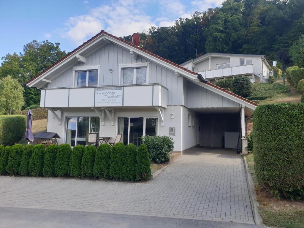 ein weißes Haus mit einer Einfahrt davor in der Unterkunft Ferienanlage Traumhaft in Wernigerode