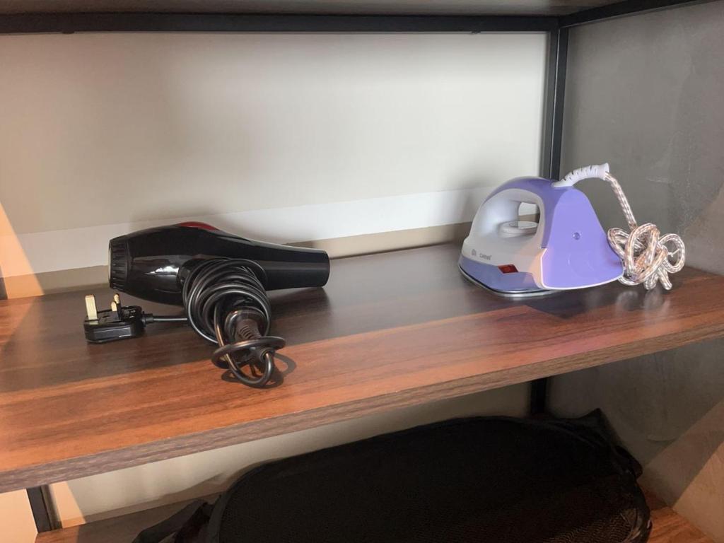 einen Schreibtisch mit einem Haartrockner und einem Telefon darauf in der Unterkunft Muji Studio USJ in Subang Jaya