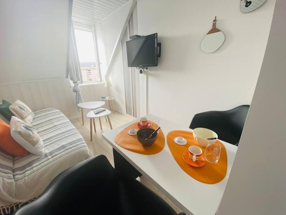 una habitación con una mesa con dos platos y tazas. en Chez Zivou au pied de la plage, en Mers-les-Bains