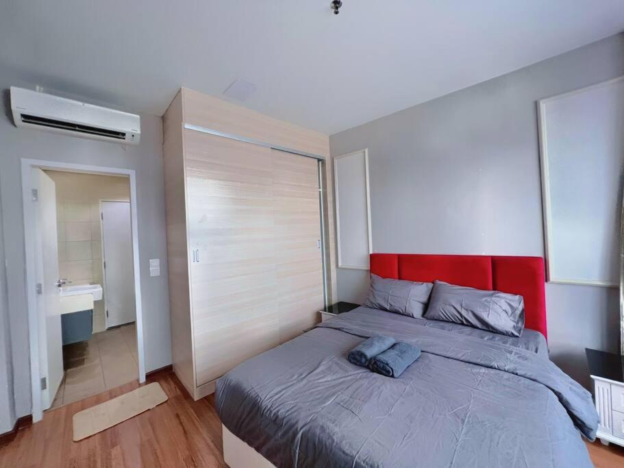 um quarto com uma cama grande e uma cabeceira vermelha em Comfy Staycation 4PX with Free Parking, Direct Linked SOGO & Central I-CITY em Shah Alam