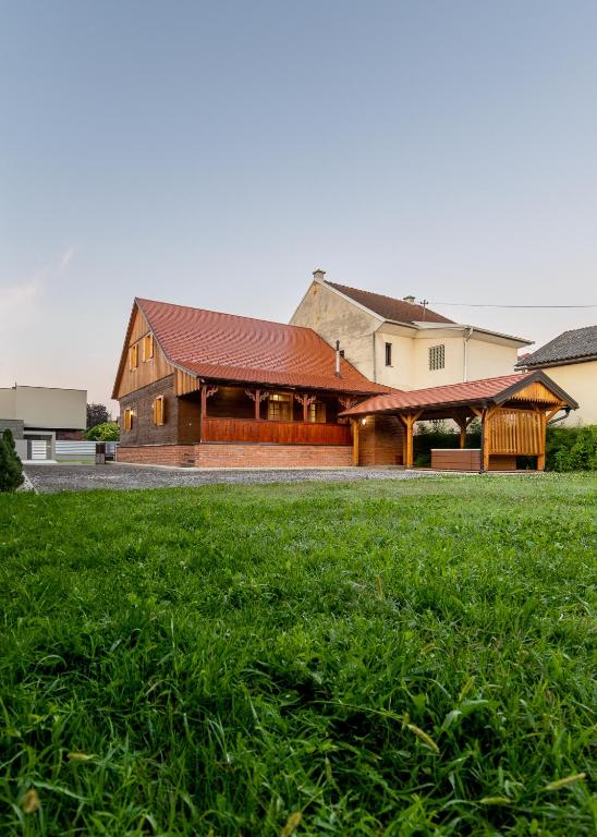 a building with a grass field in front of it at Vila IVAN in Velika Gorica