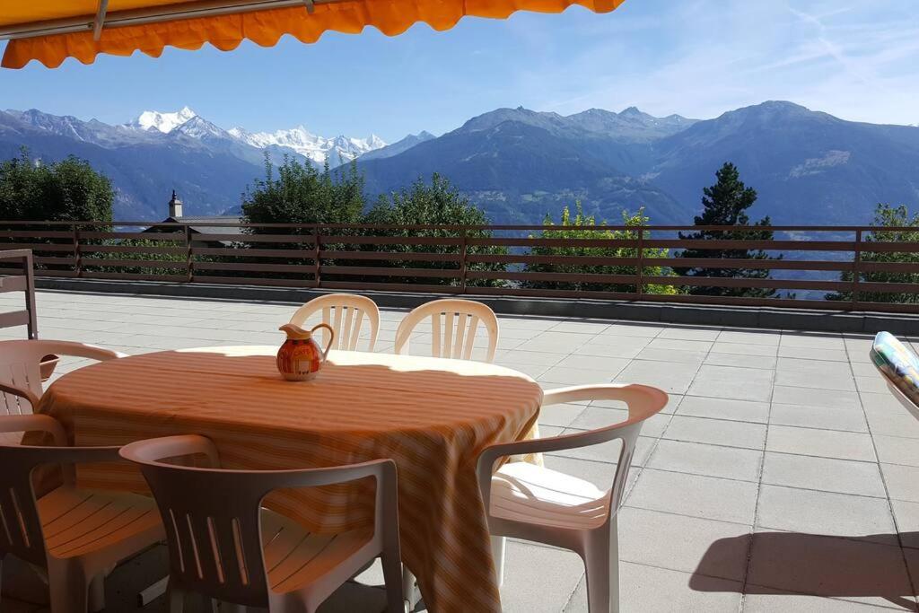 a cat sitting on top of a table on a patio at Sunny 2 BR w large terrace, stunning views & pool in Crans-Montana