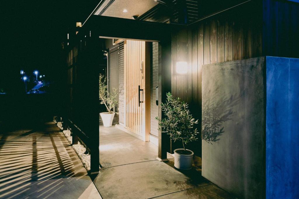 un couloir d'une maison avec des plantes en pot dans l'établissement 結びの小宿 縁, à Kobe
