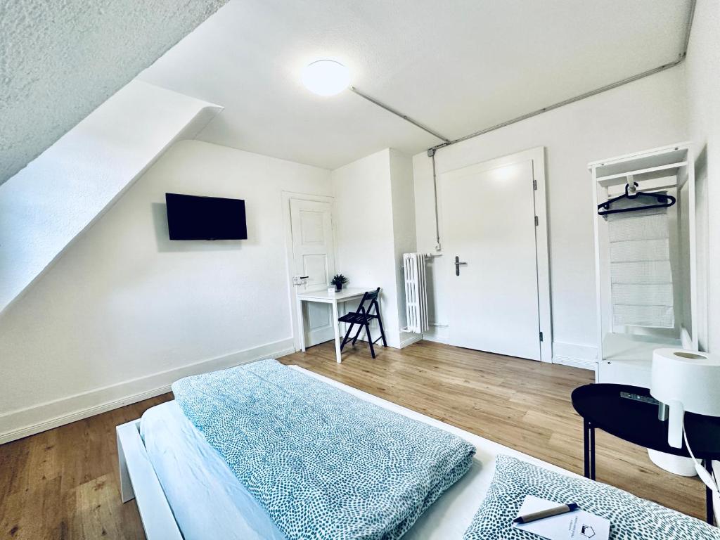 a white bedroom with a bed and a desk at Monteurzimmer ZIMMERzuVERMIETEN in Balsthal Solothurn in Balsthal