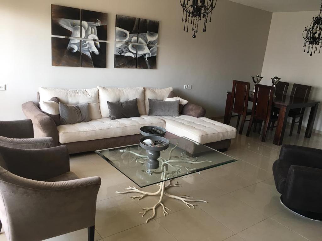Haatsmaout City center apartment Ashdod في أشدود: غرفة معيشة مع أريكة وطاولة زجاجية