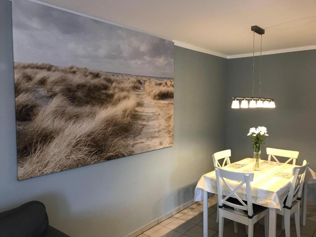 uma sala de jantar com uma mesa e um quadro na parede em Ferienwohnung-Fehmarnsund em Petersdorf auf Fehmarn