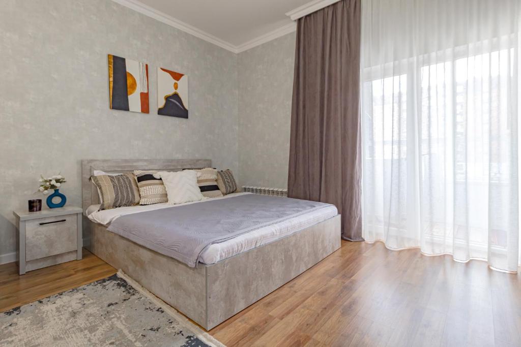 アスタナにあるАпартаменты в ЖК Apple Cityのベッドと大きな窓のある寝室