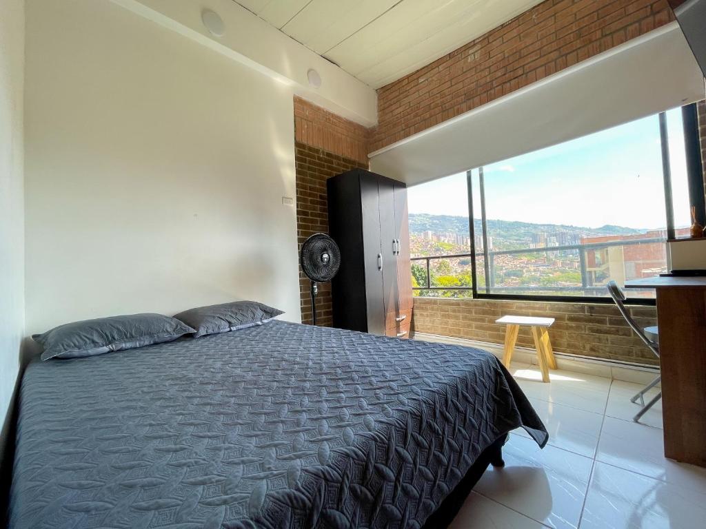 1 dormitorio con cama y ventana grande en Apartamentos Privados y extraordinarios en Medellín, en Medellín