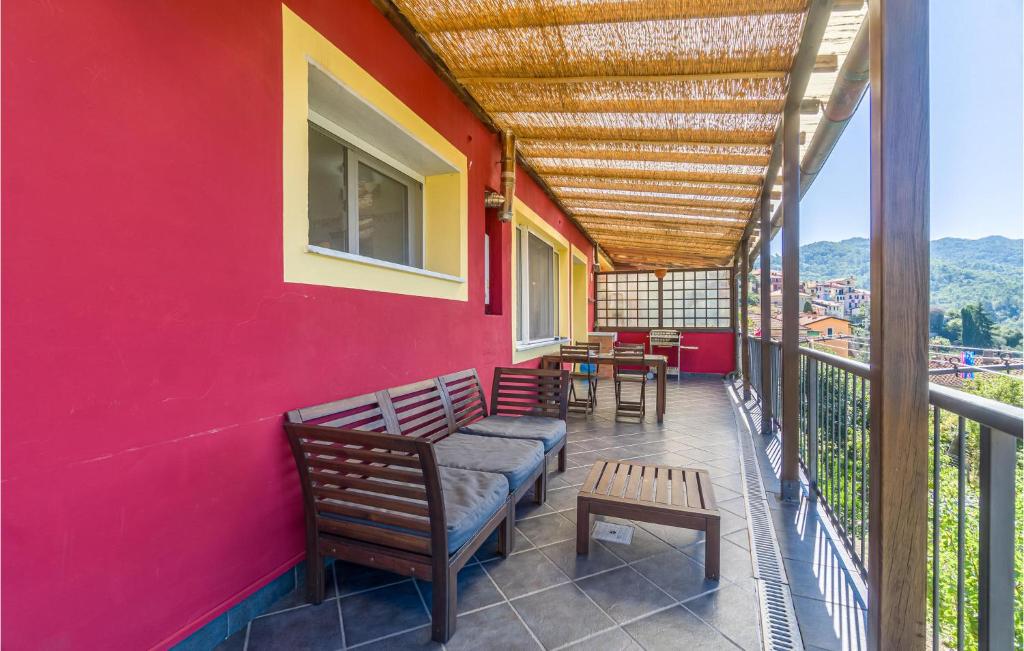 a balcony with benches and tables on a red wall at Casa Relax In Collina in Castiglione Chiavarese