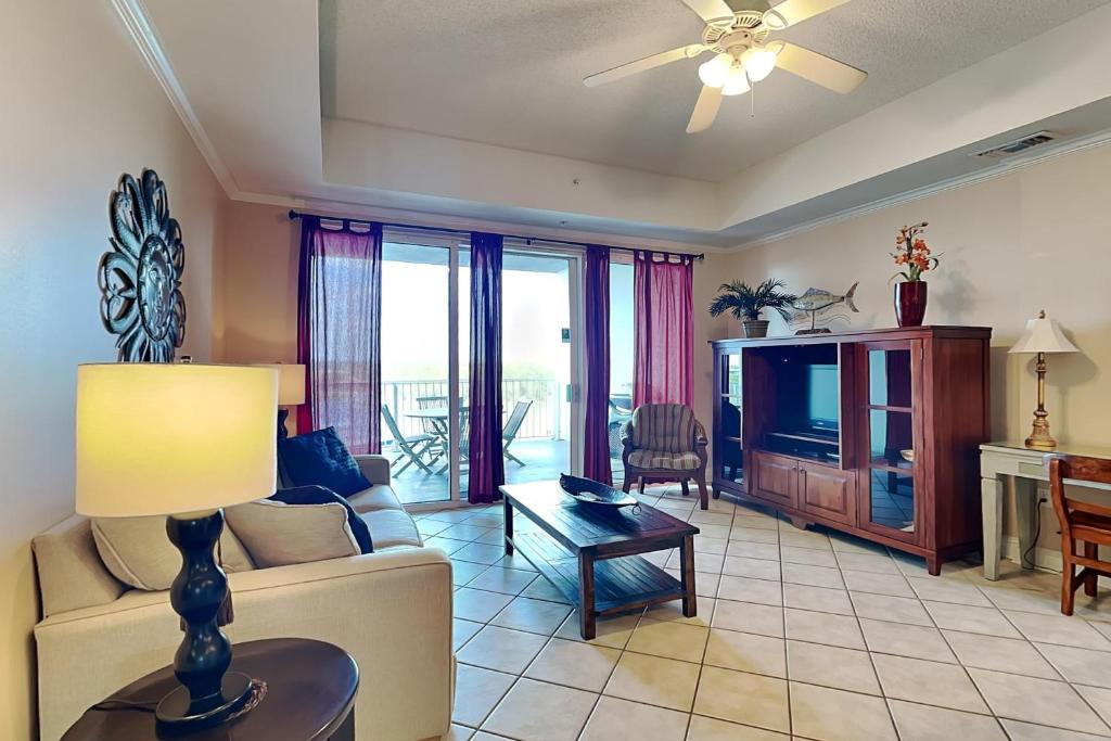 uma sala de estar com um sofá e uma televisão em Wharf #506 em Orange Beach