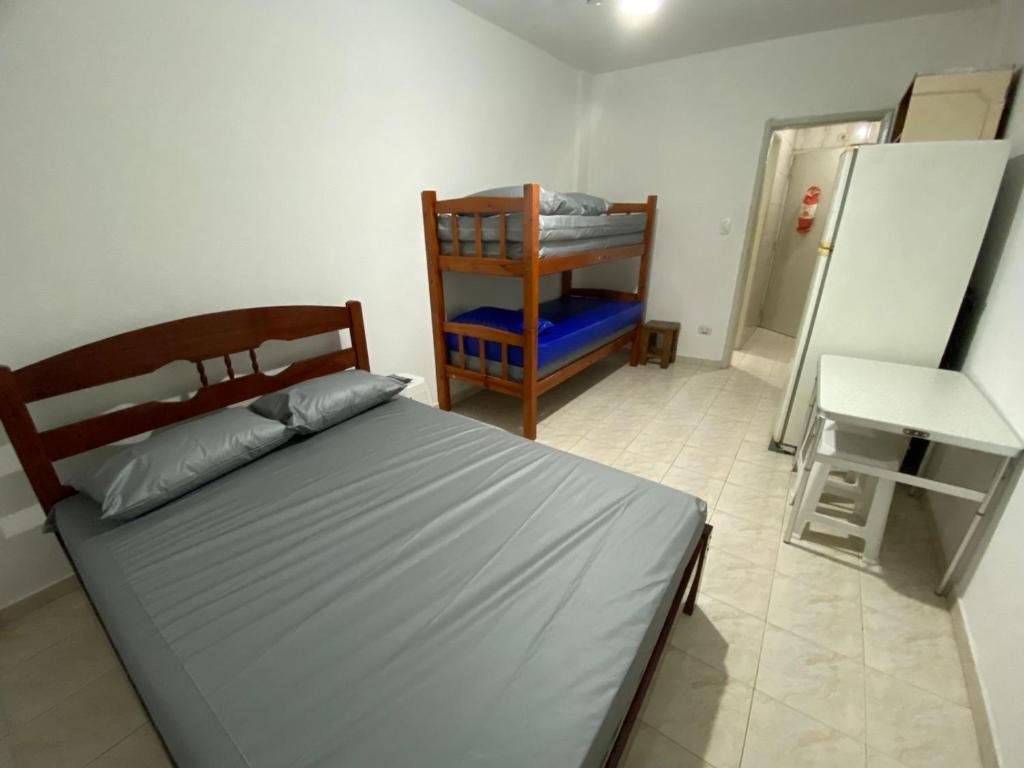 - une chambre avec un lit, une table et une chaise dans l'établissement Lindo kit na quadra da praia, à Santos