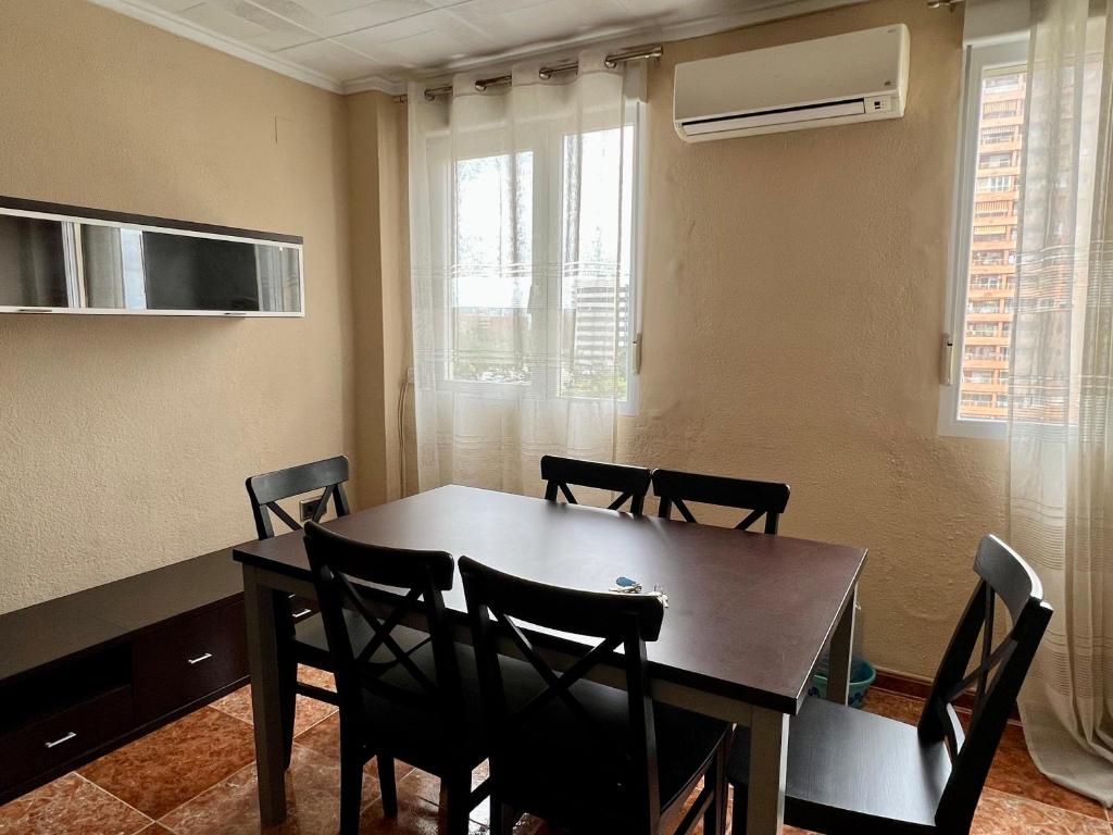 Habitación con mesa de comedor y sillas. en Bonito apartamento cerca de la playa, en Valencia