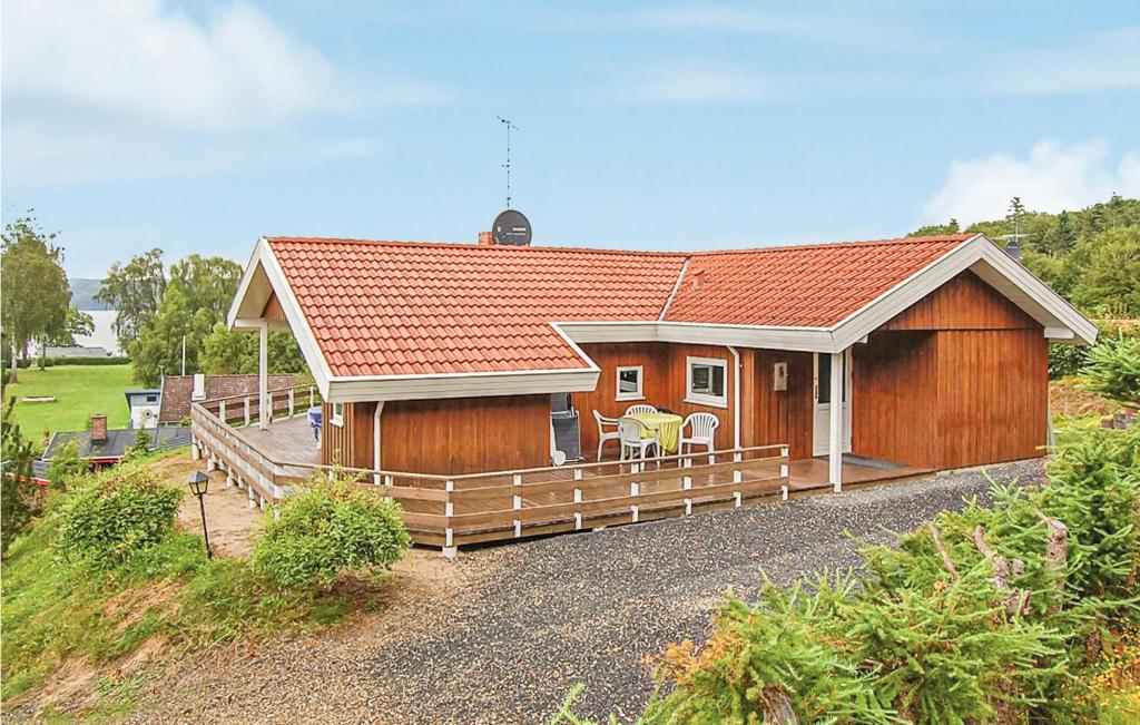 a large wooden house with a large deck at Lovely Home In Brkop With Kitchen in Brejning