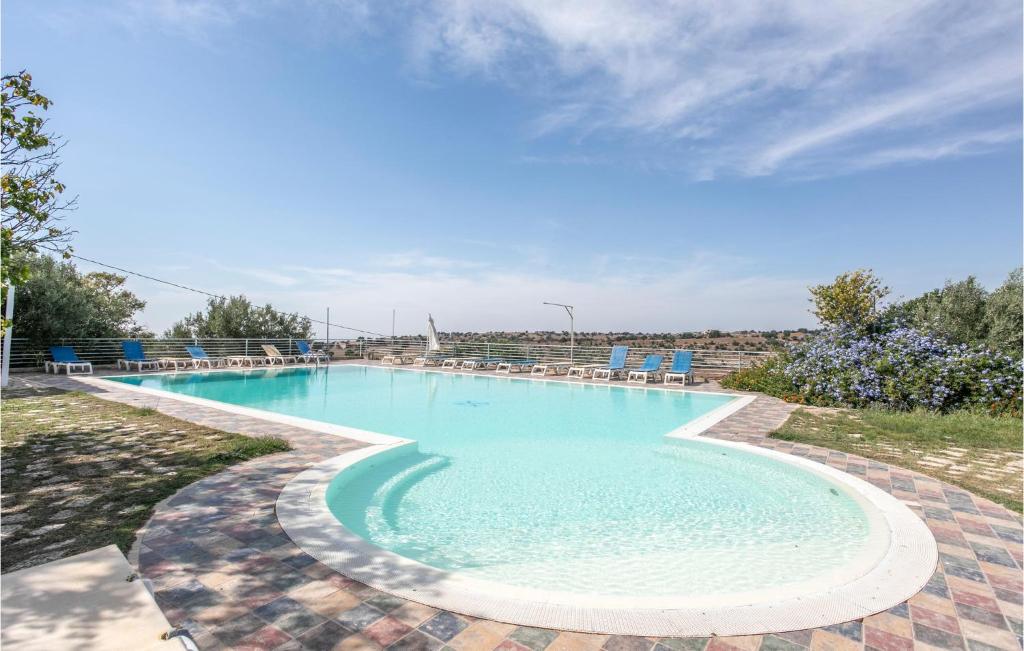 a large swimming pool with chairs in a yard at Tenuta Licitra in Ragusa