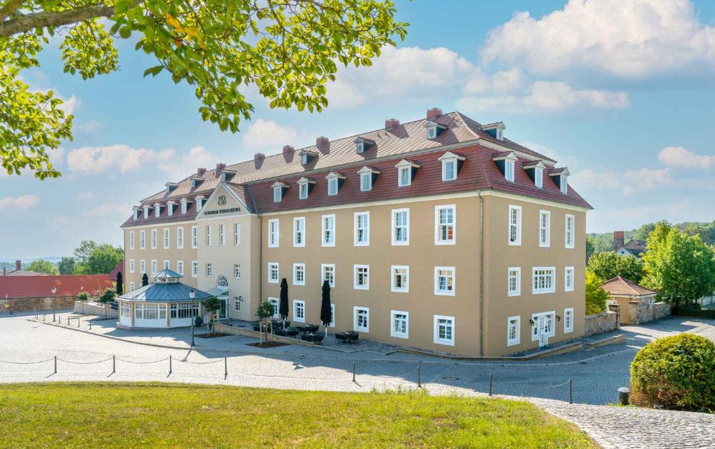 ein großes, braunes Gebäude mit rotem Dach in der Unterkunft Bernstein Schlosshotel Ballenstedt in Ballenstedt