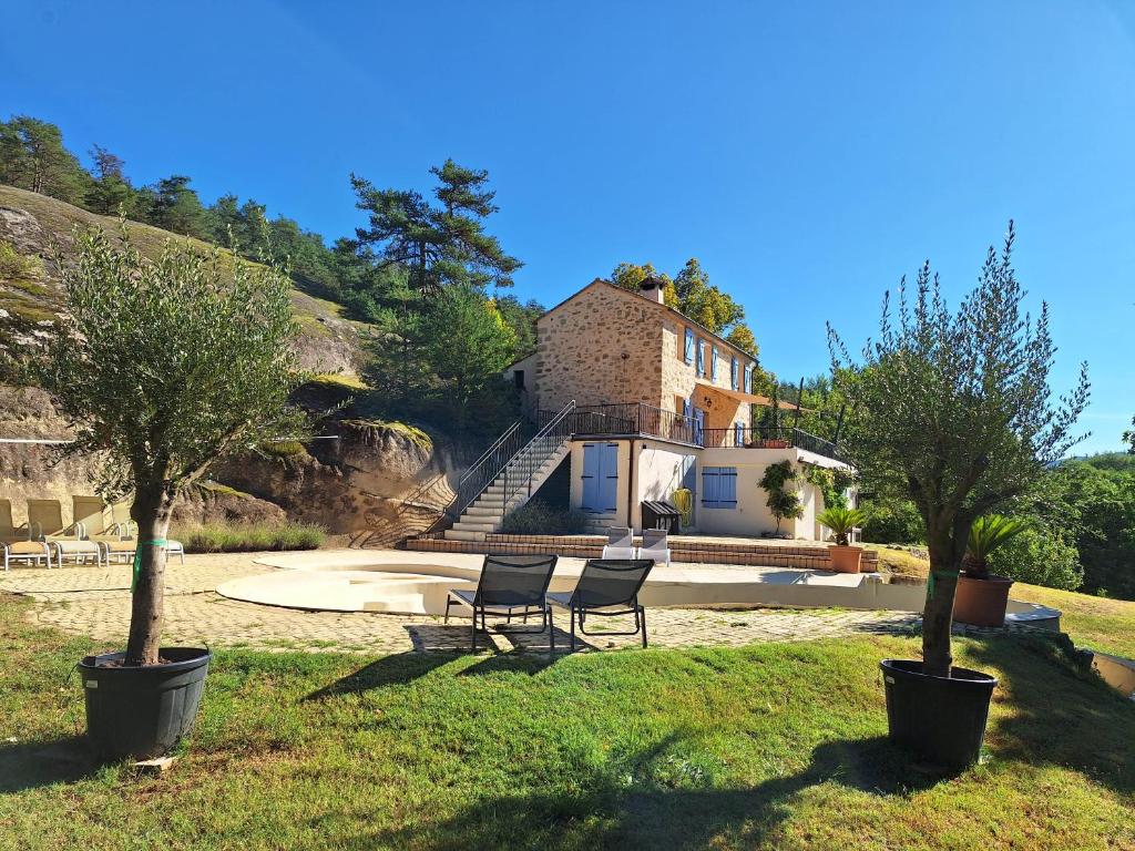 una casa en una colina con dos sillas en el césped en Romantic-Louveteaux-en-Provence****, en Saint-Pierre