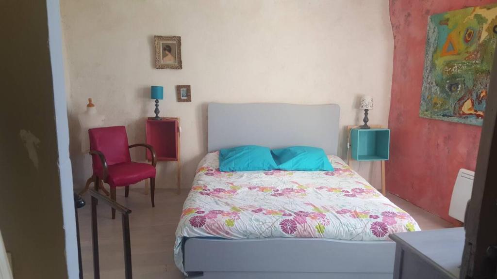 une chambre avec un lit et deux chaises dans l'établissement Gîte la Bibliothèque, à Saint-Martin-le-Supérieur
