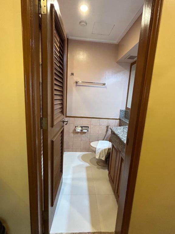 y baño con aseo y lavamanos. en Private Unit at The Camp John Hay Manor, en Baguio