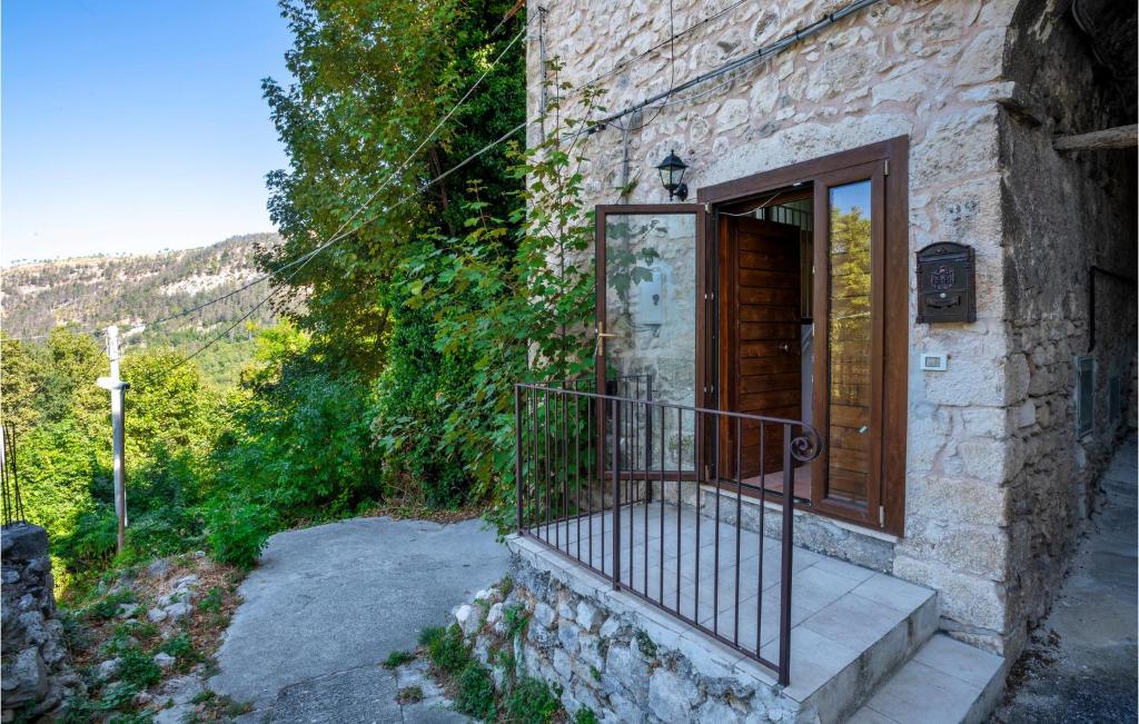 kamienny dom z drewnianymi drzwiami i balkonem w obiekcie Beautiful Apartment In Caramanico Terme With 4 Bedrooms w mieście Caramanico Terme