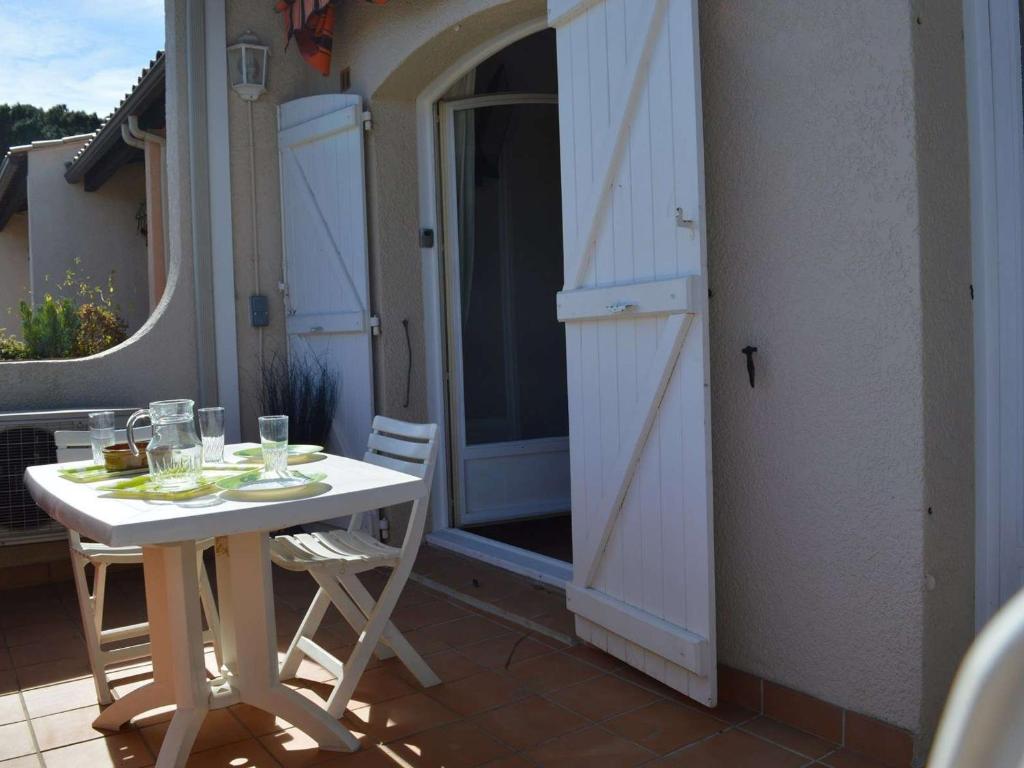 une table et des chaises sur un balcon avec une porte ouverte dans l'établissement Studio Mezzanine Climatisé avec Terrasse, Parking Privé et Proche Plage à Cavalaire - FR-1-226B-30, à Cavalaire-sur-Mer