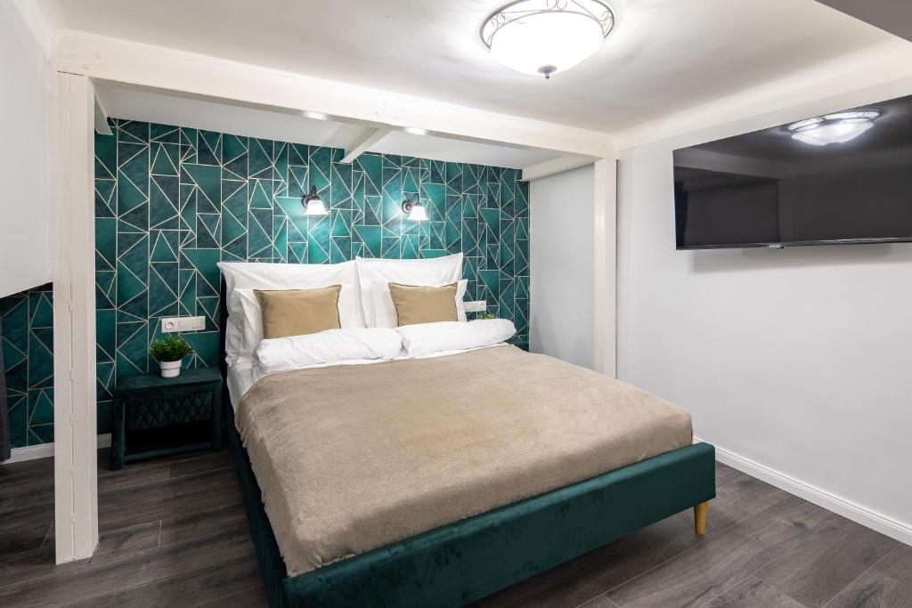a bedroom with a bed with a green accent wall at Dessewffy Premium Apartment in Budapest