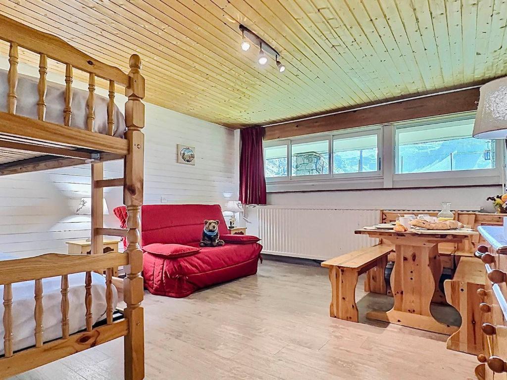 un salon avec un canapé rouge et une table dans l'établissement Tignes Le Lac - Appt cosy 32m², 4 pers, Pied des pistes, Sud-Est, Animaux OK, Équipé & Fonctionnel - FR-1-411-149, à Tignes