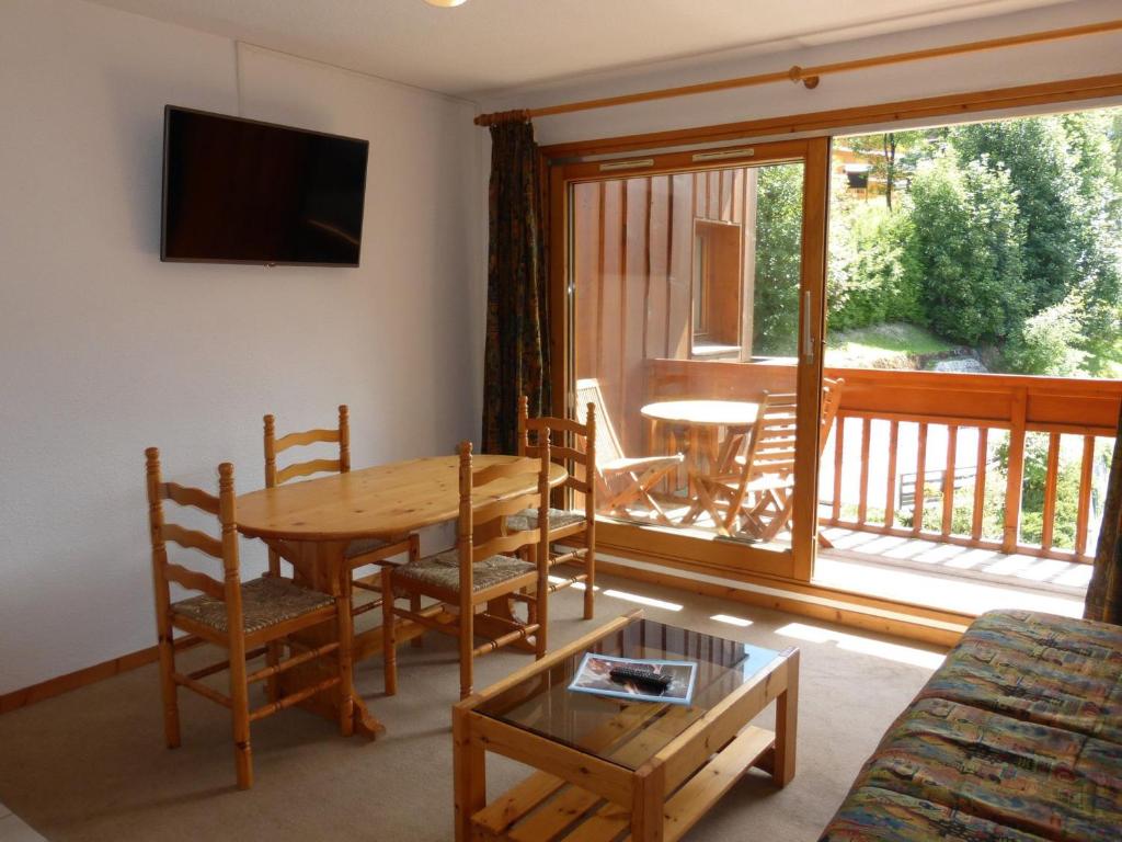 Il comprend un salon avec une table en bois et un balcon. dans l'établissement Appartement 2 pièces avec Piscine, WiFi et Garage à Méribel Centre - FR-1-411-654, à Les Allues