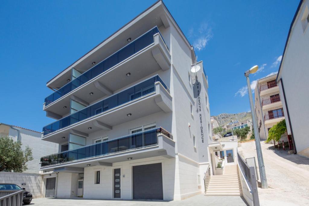 un edificio de apartamentos blanco con balcones azules en Apartments The Seasons Residence en Omiš