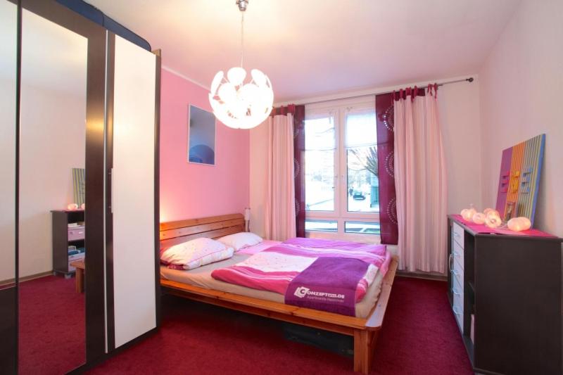 Schlafzimmer mit einem Bett mit rosa Bettwäsche und einem Fenster in der Unterkunft Private Rooms in Hannover