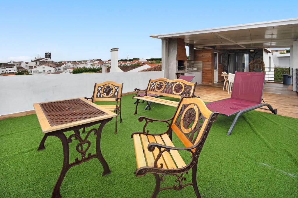 a group of chairs and tables on a lawn at Alojamento Lagoa in Lagoa