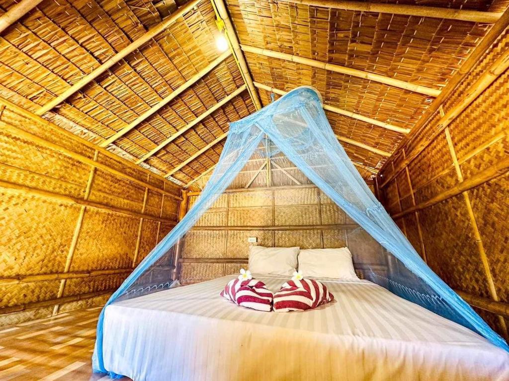 uma cama numa cabana de palha com uma rede mosquiteira em Check in Lanta em Ko Lanta