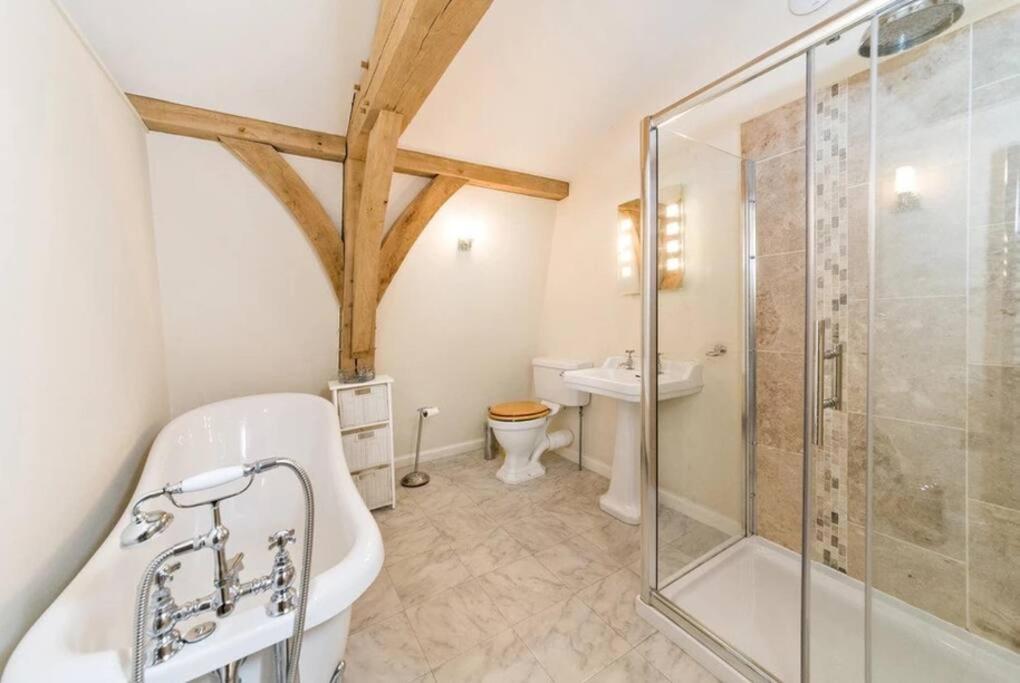 a bathroom with a shower and a tub and a toilet at Boat House Middleton Hall Estate in Belford