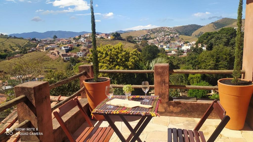 einen Tisch und Stühle auf einem Balkon mit Aussicht in der Unterkunft SUÍTE VISTA LINDA in Cunha