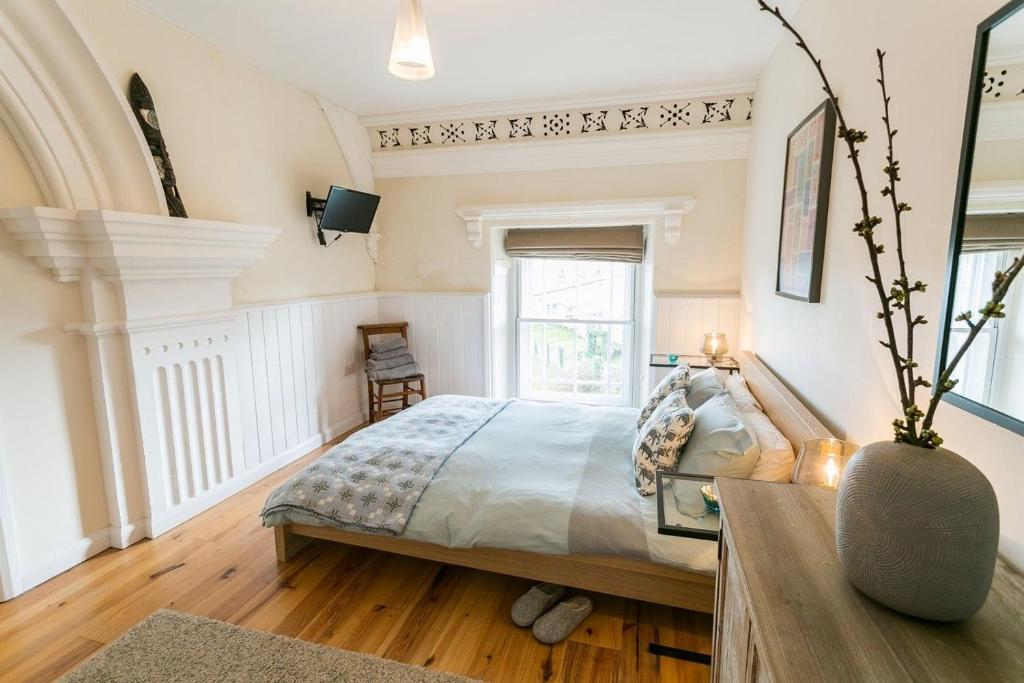 - une chambre avec un grand lit et une fenêtre dans l'établissement Cwyfan, à Aberffraw