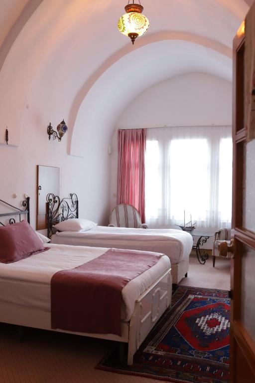 a bedroom with two beds in a room with a window at Cappadocia Landscape House in Nevsehir