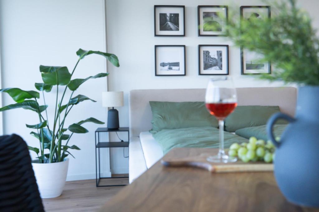 un bicchiere di vino su un tavolo in soggiorno di Helles Apartment mit tollem Blick über Augsburg a Augusta (Augsburg)