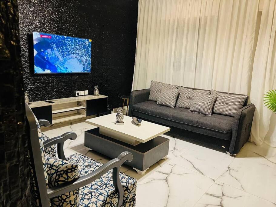 ein Wohnzimmer mit einem Sofa und einem Tisch in der Unterkunft Luxury 4-bedrooms apartment in Aqaba
