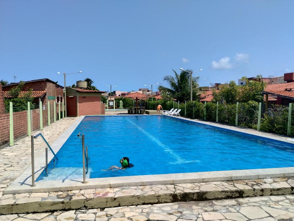 una persona che nuota in una piscina di Casa em Tamandaré a 1km de Carneiros no Condomínio Cote d' Azur a Tamandaré