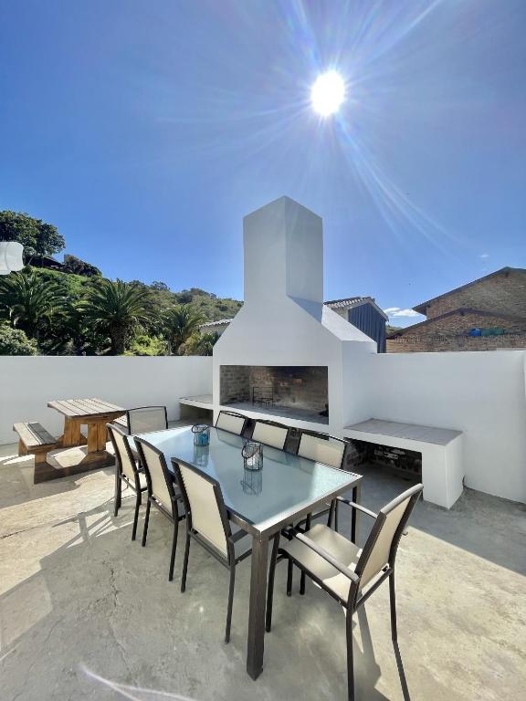un patio con tavolo, sedie e camino di LTB-Waterkant Cottage a Malgas