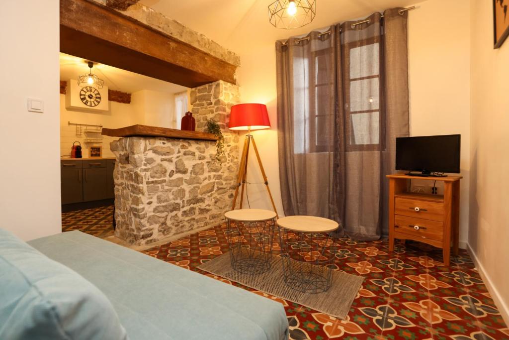 - une chambre avec un lit, une télévision et une cheminée dans l'établissement Studio du Charme Médiéval ConciergerieDameCarcas, à Carcassonne