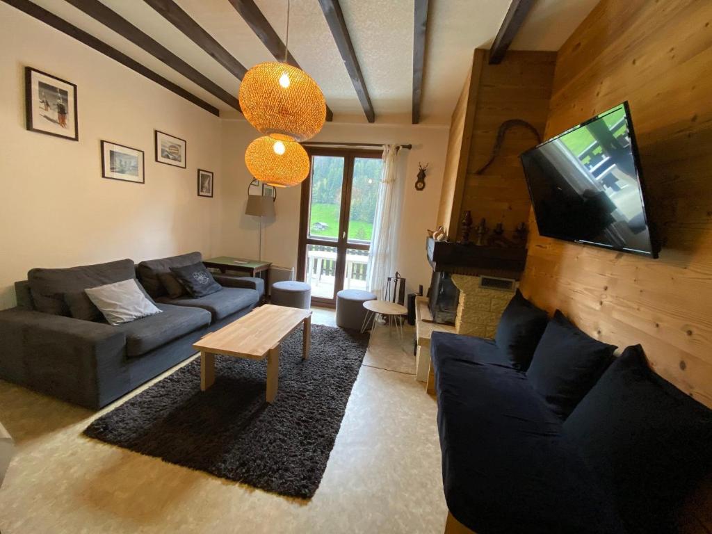 un salon avec un canapé et une télévision dans l'établissement Appartement spacieux, 9 personnes, 3 chambres, 1 mezzanine - ARA101, à Beaufort