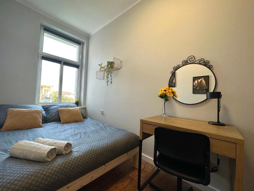sypialnia z łóżkiem, biurkiem i lustrem w obiekcie MMRent Sunflower Room w Gdańsku