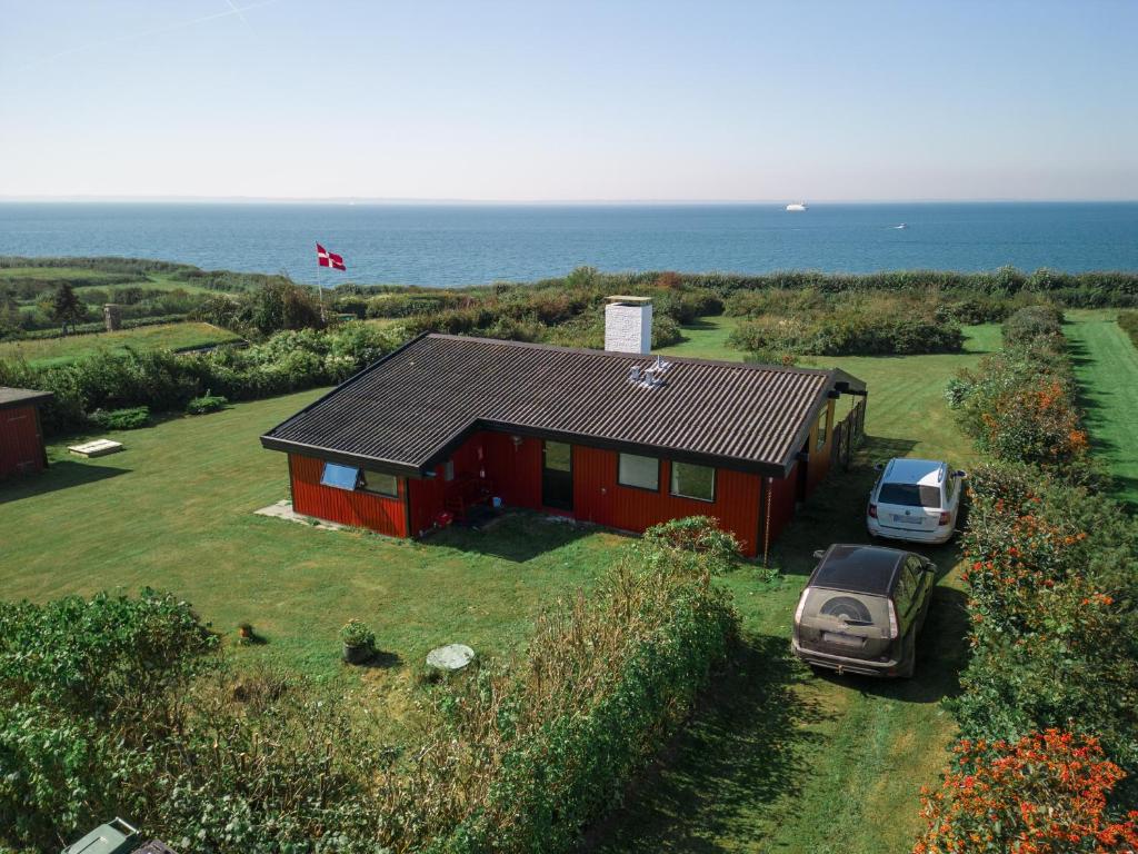 a red house with a car parked in front of it at Magnificent house with splendid view to the sea in Fåborg