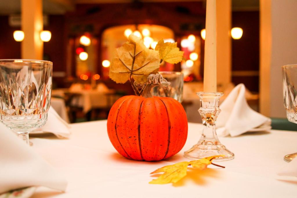 an orange pumpkin sitting on a table with glasses at Fullerton Inn & Restaurant in Chester