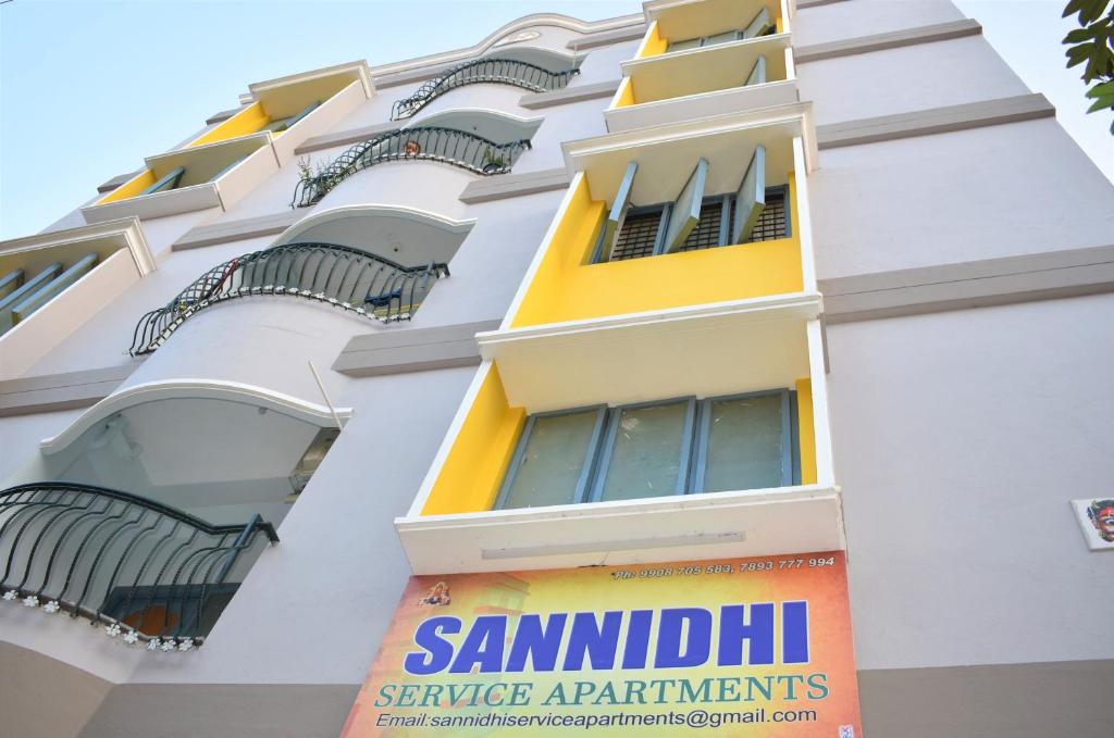 un edificio con balcones y una señal en él en Sannidhi Service Apartments, en Tirupati