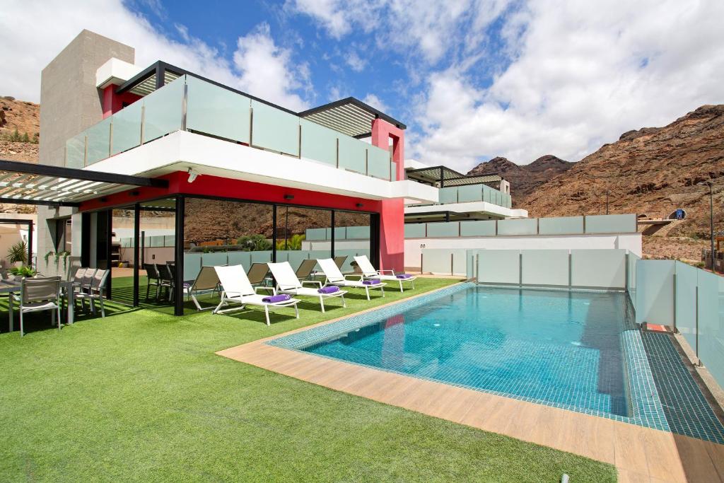 a modern house with a swimming pool and lawn at Villa Tauro 31 in Mogán