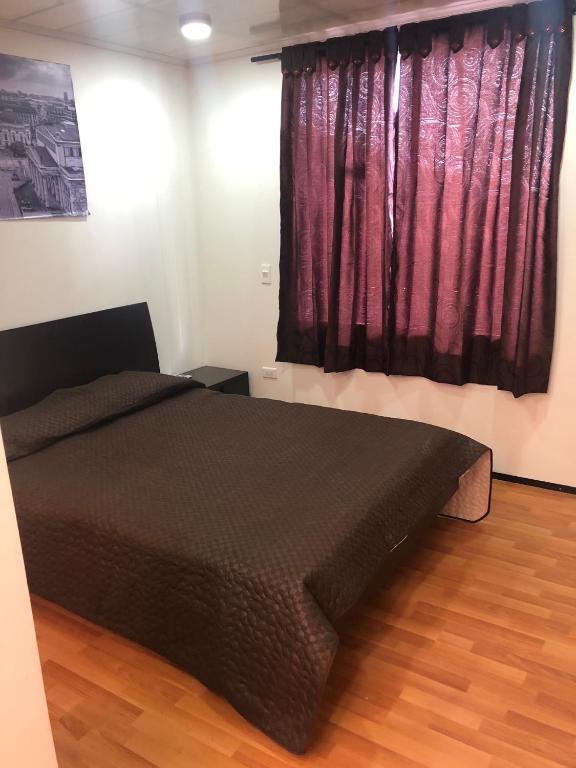 um quarto com uma cama e uma janela com cortinas cor-de-rosa em Apta estudio bien ubicado em Bogotá
