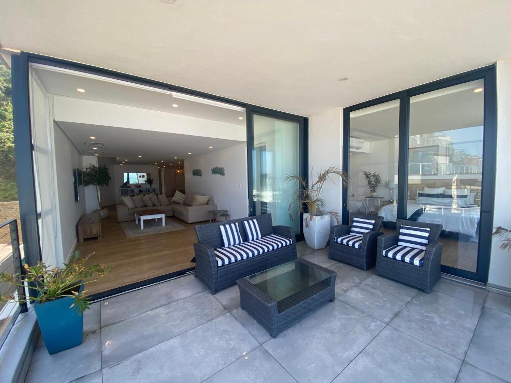 un patio con 2 sofás y una sala de estar. en Sea La Vie - with Inverter, en Umdloti